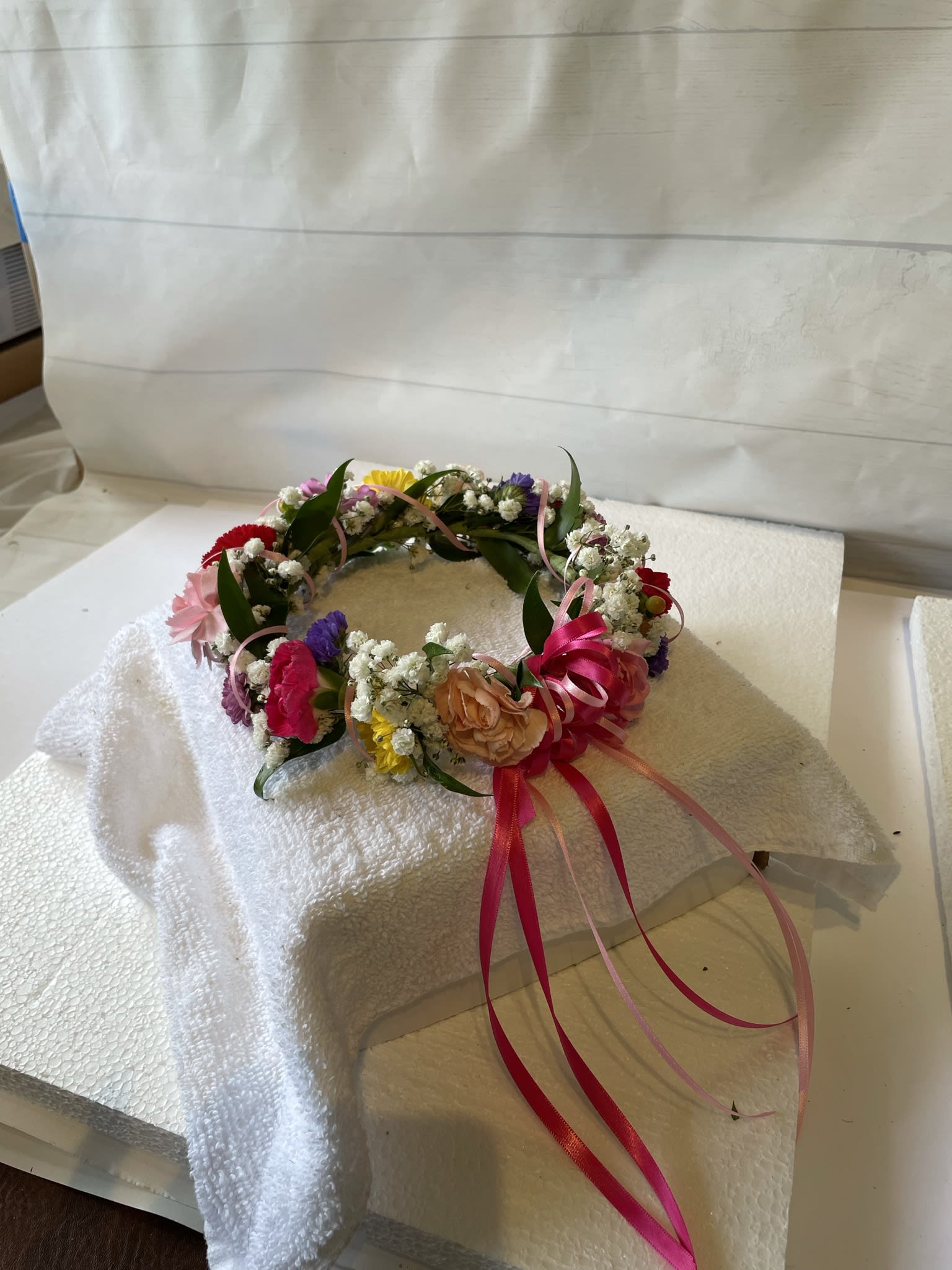 Floral crown with pink, yellow, purple, and white flowers and ribbon streamers