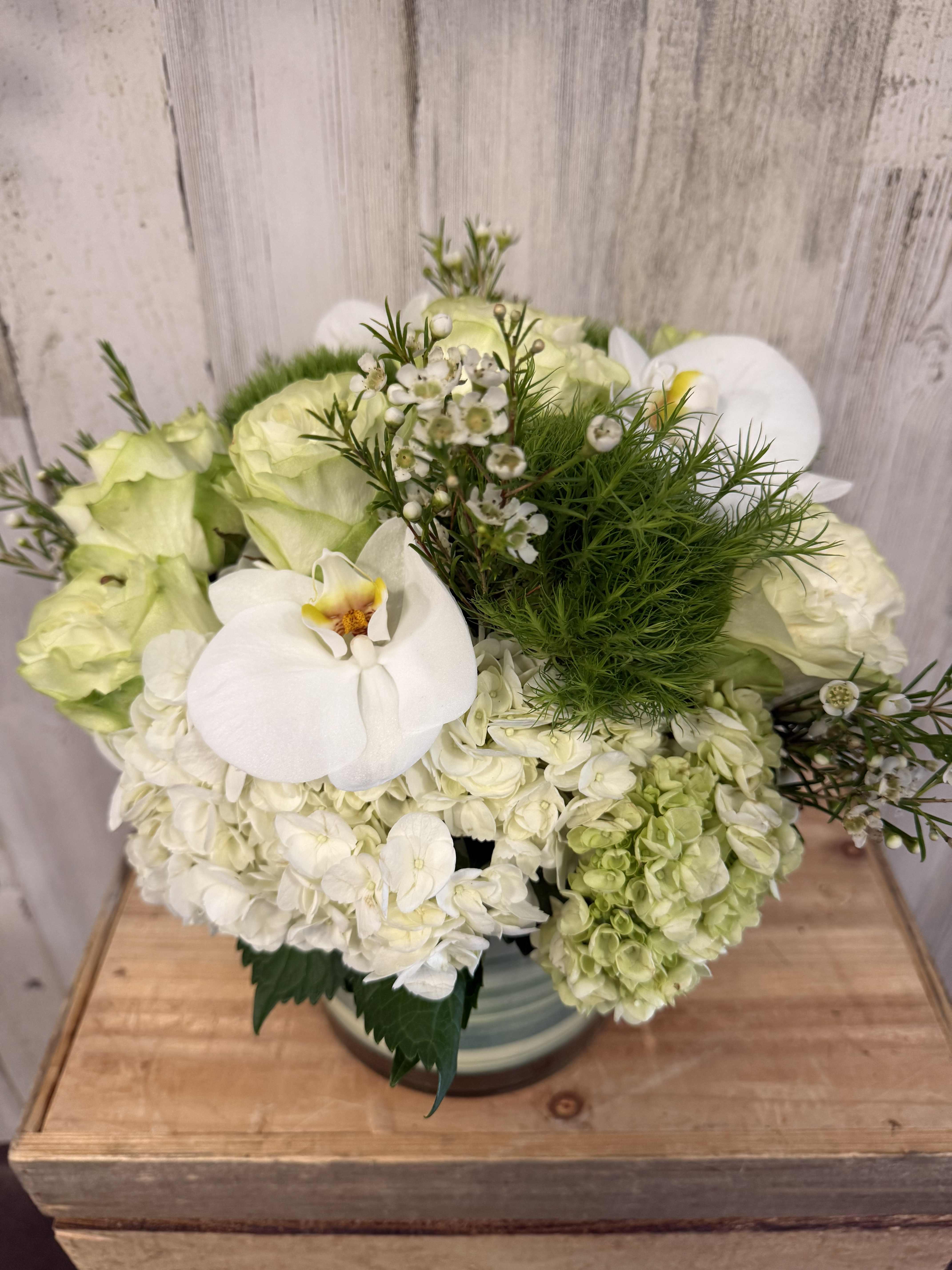 White orchid and pale green hydrangea bouquet in a vase