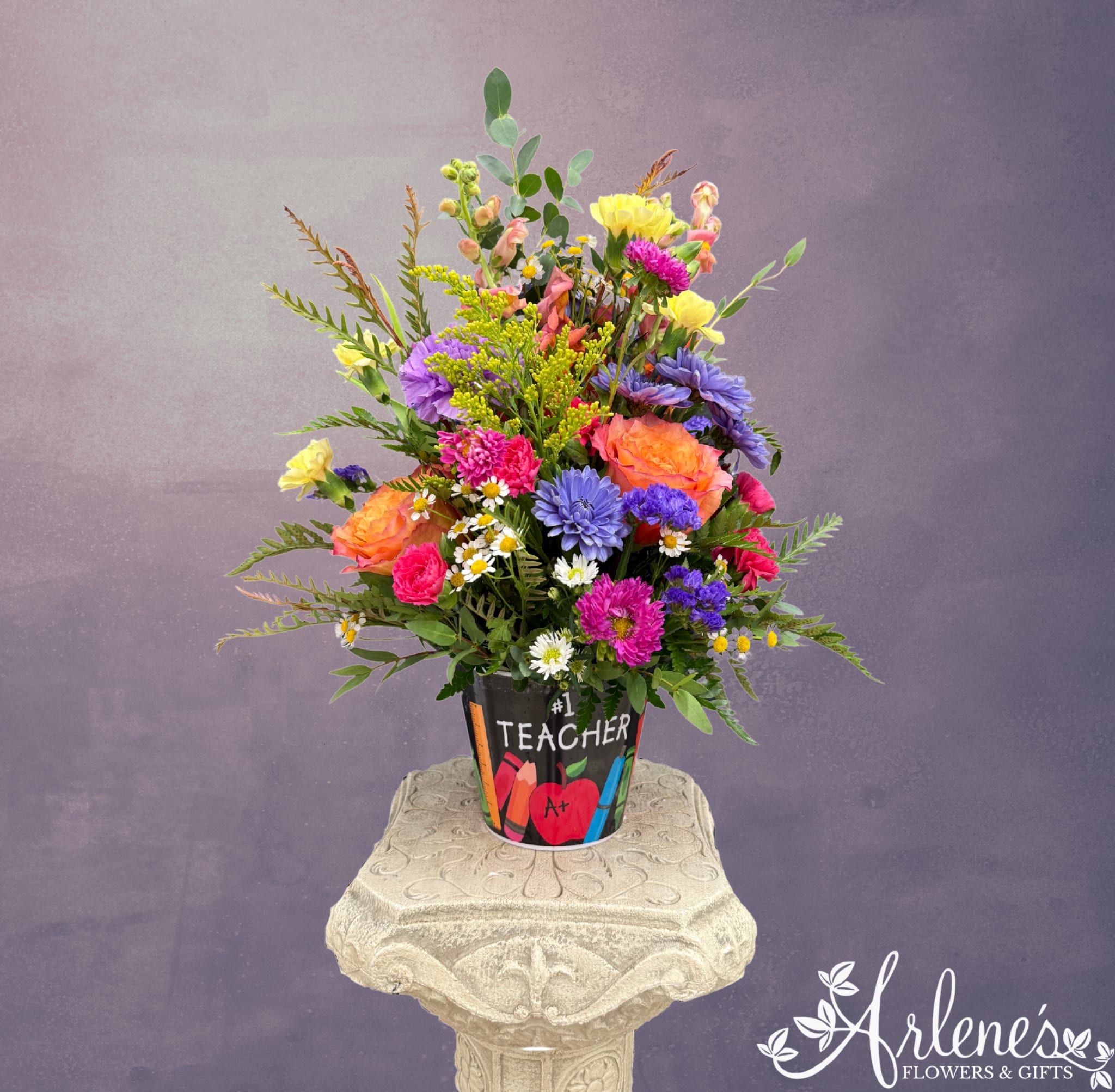 Colorful mixed bouquet in a black teacher-themed container