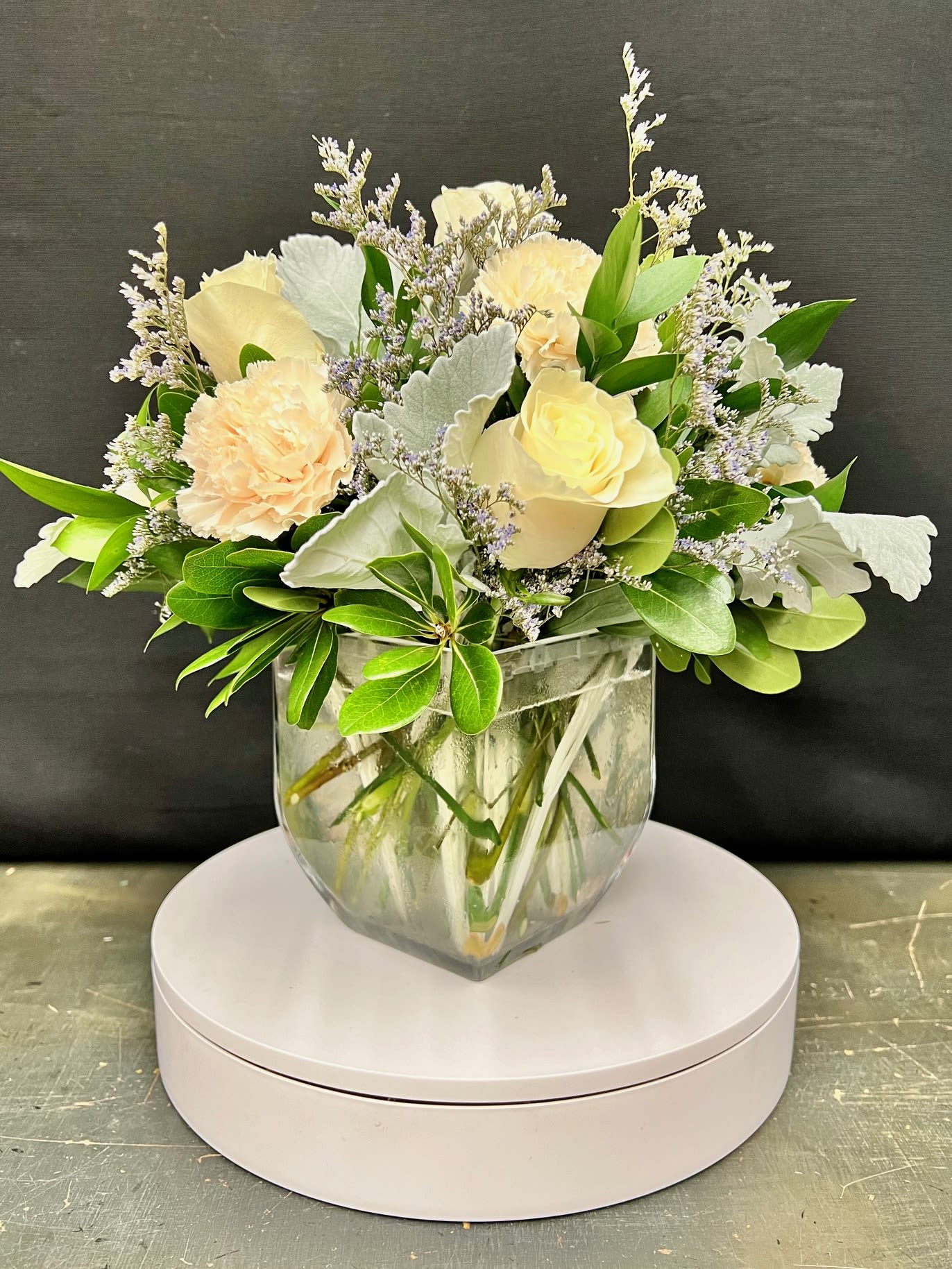 Cream and peach floral arrangement in a clear glass vase