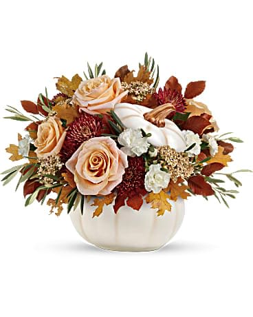 Autumn floral arrangement in a white pumpkin-shaped vase with peach roses and white blooms