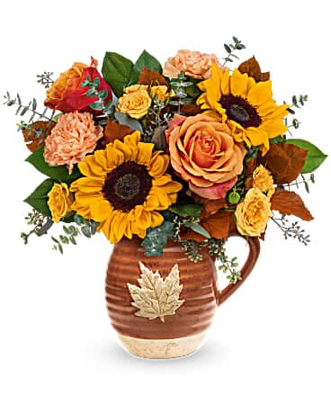 Autumn bouquet of sunflowers and roses in a brown ceramic pitcher