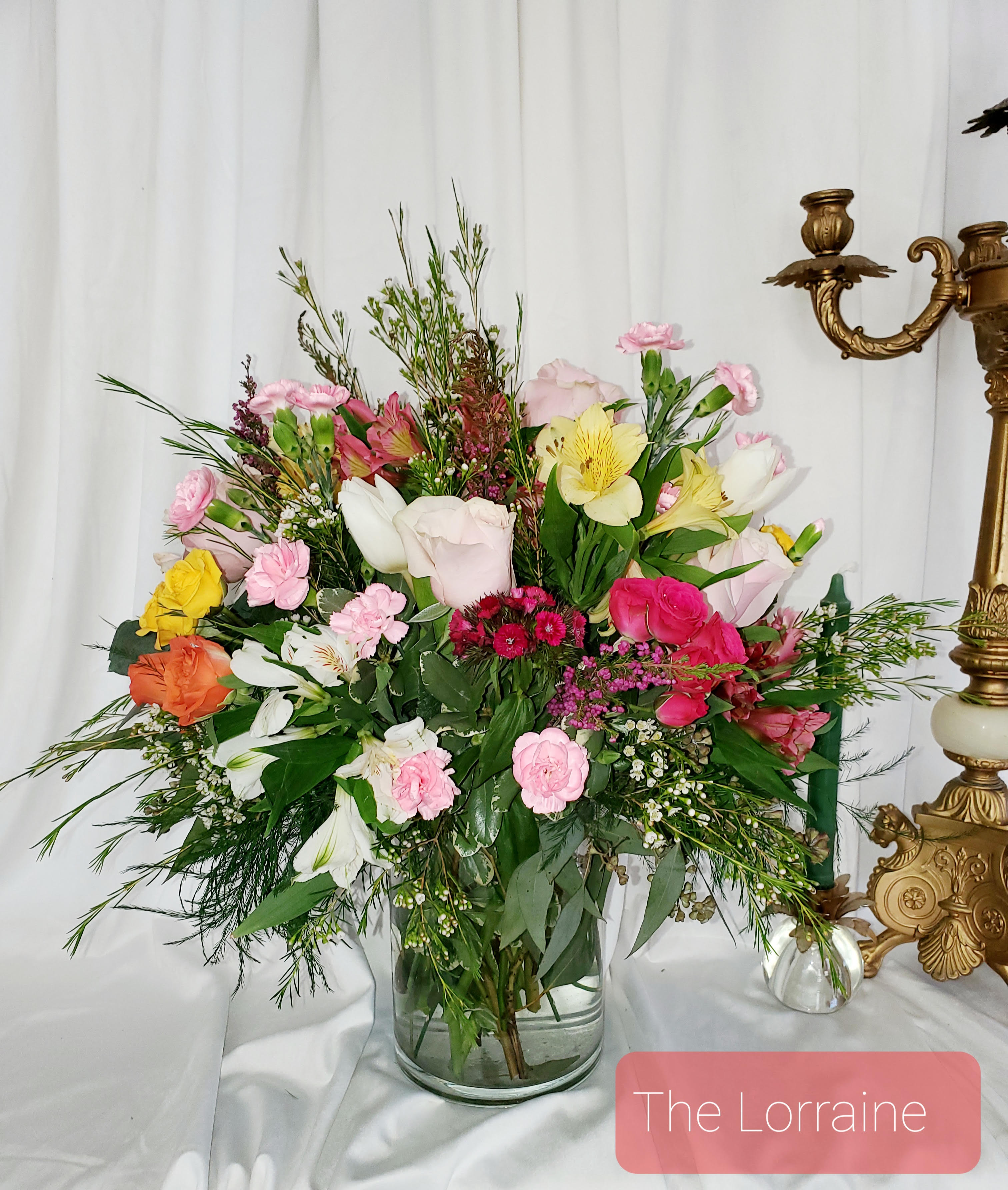 Mixed bouquet in a clear glass vase with pink, white, yellow, and orange flowers