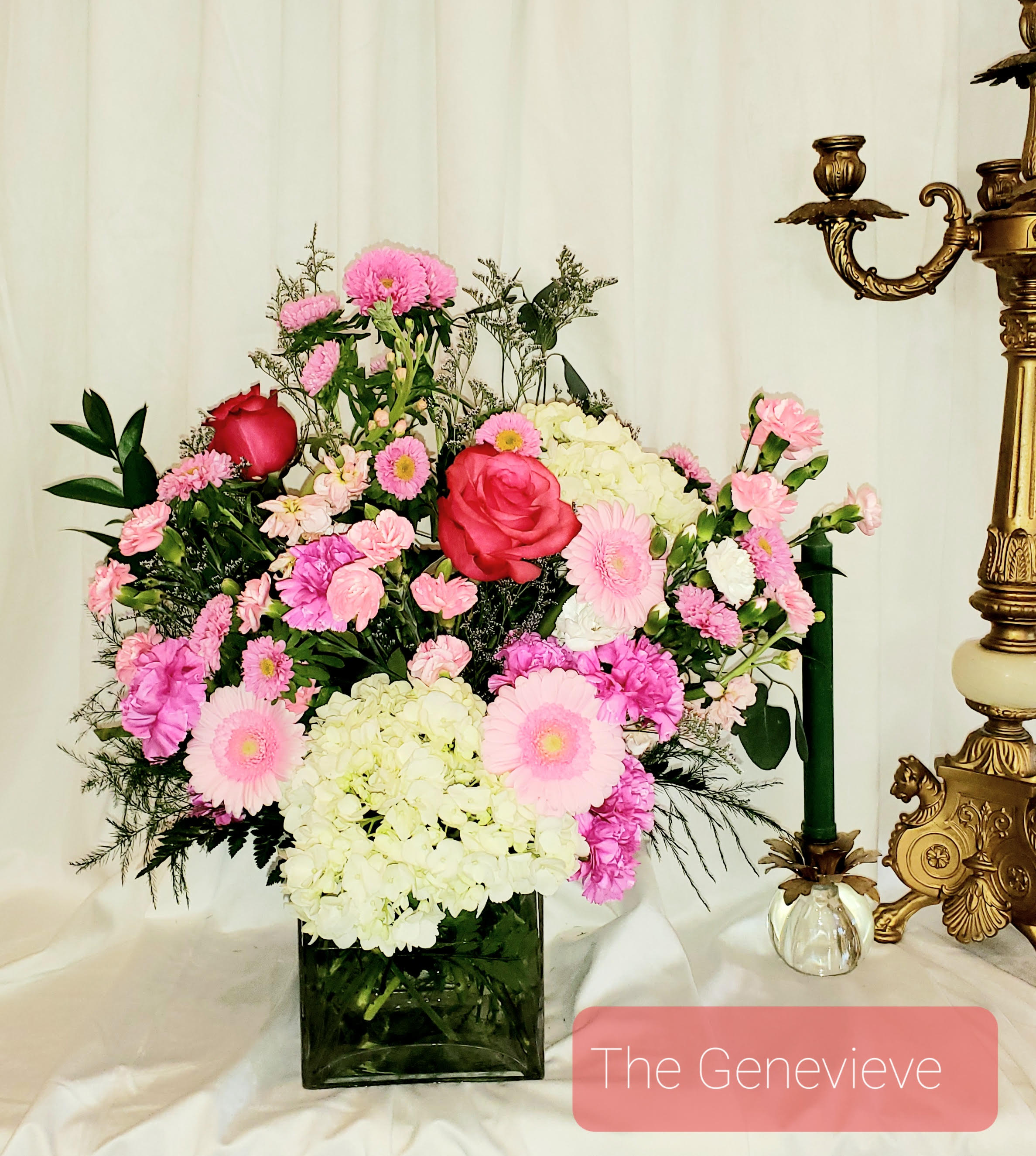 Pink and white floral arrangement in a square glass vase