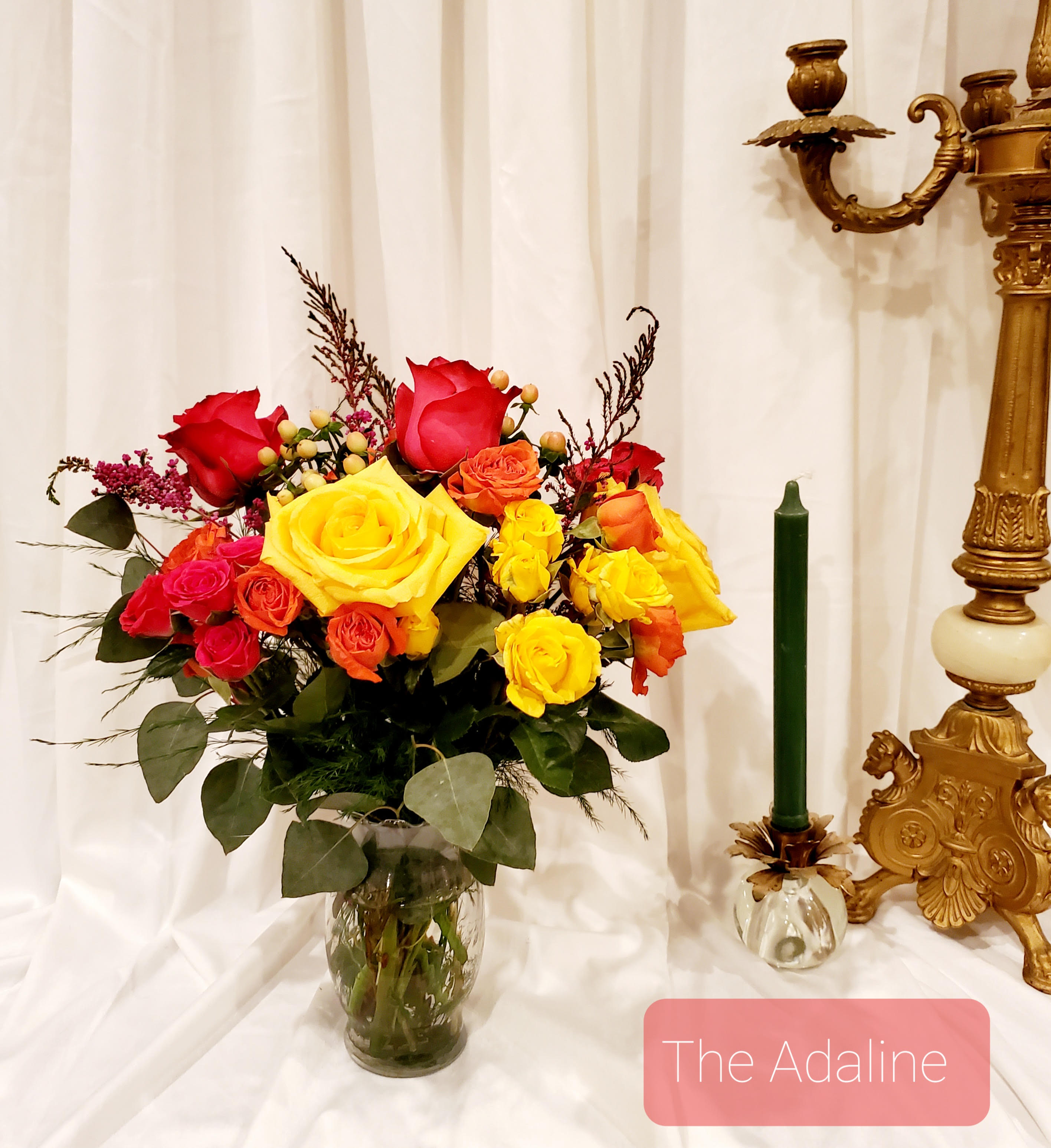 Bouquet of red, yellow, and orange roses in a glass vase