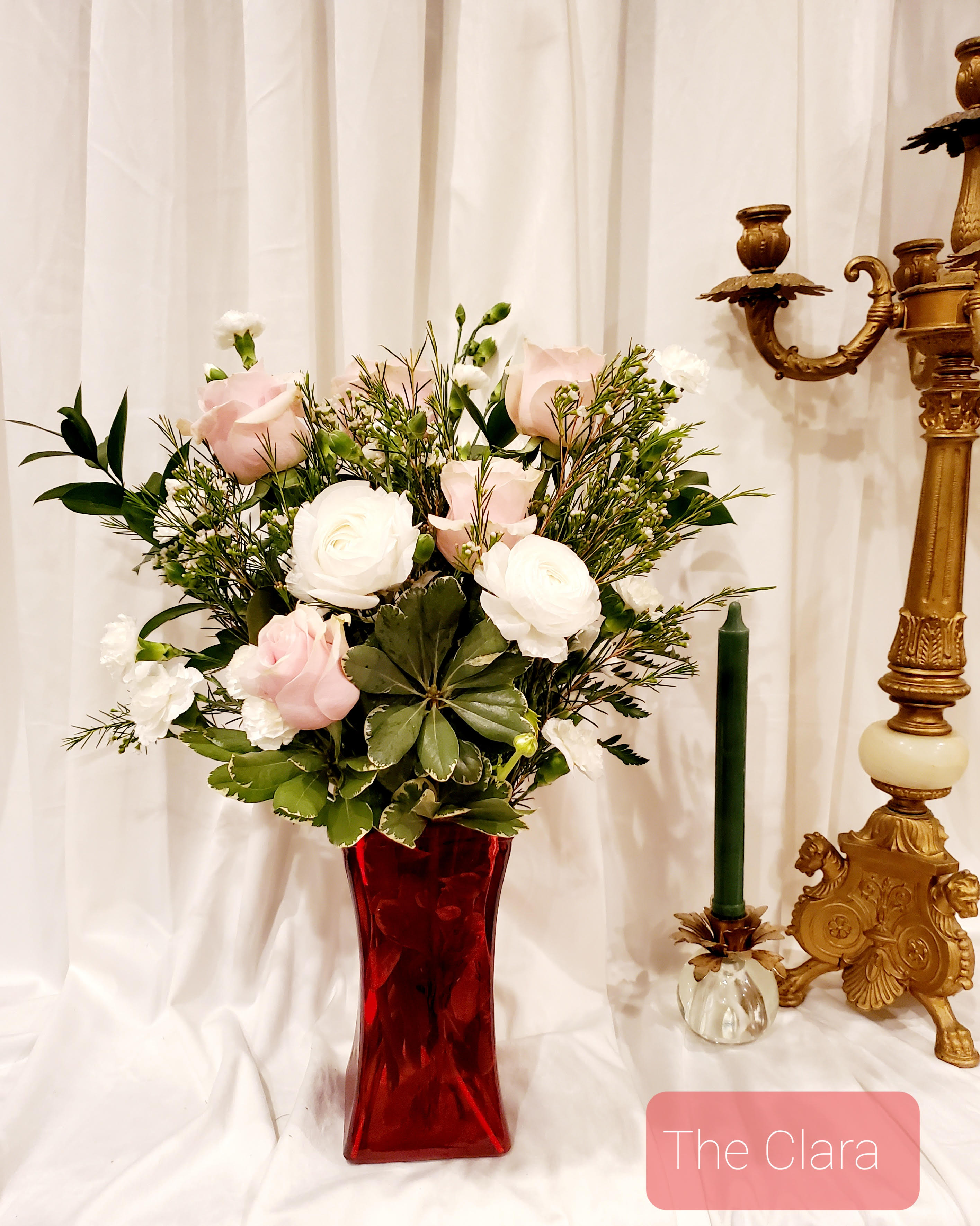 Pink and white roses in a red glass vase