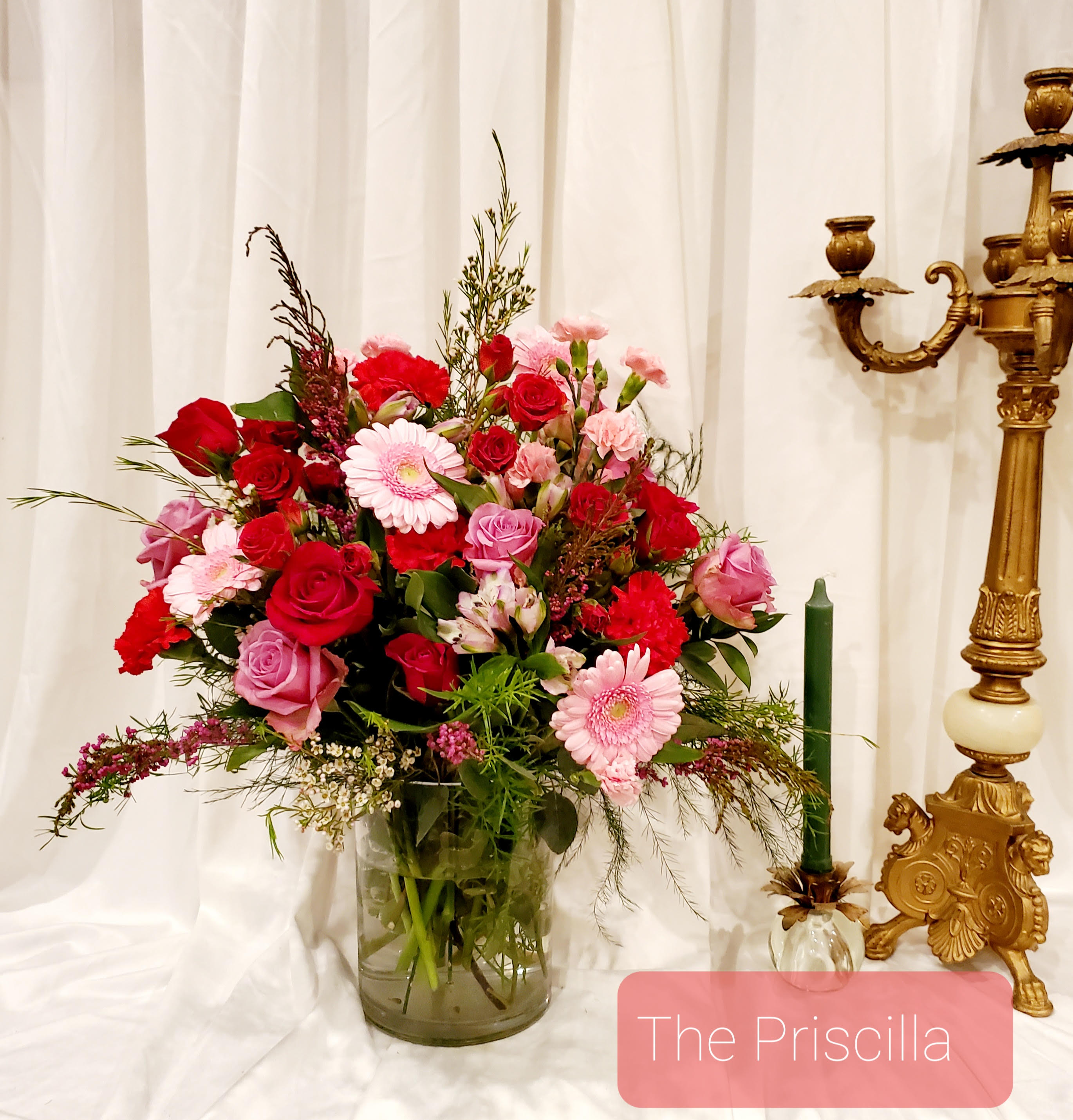 Mixed pink and red flower arrangement in a glass vase