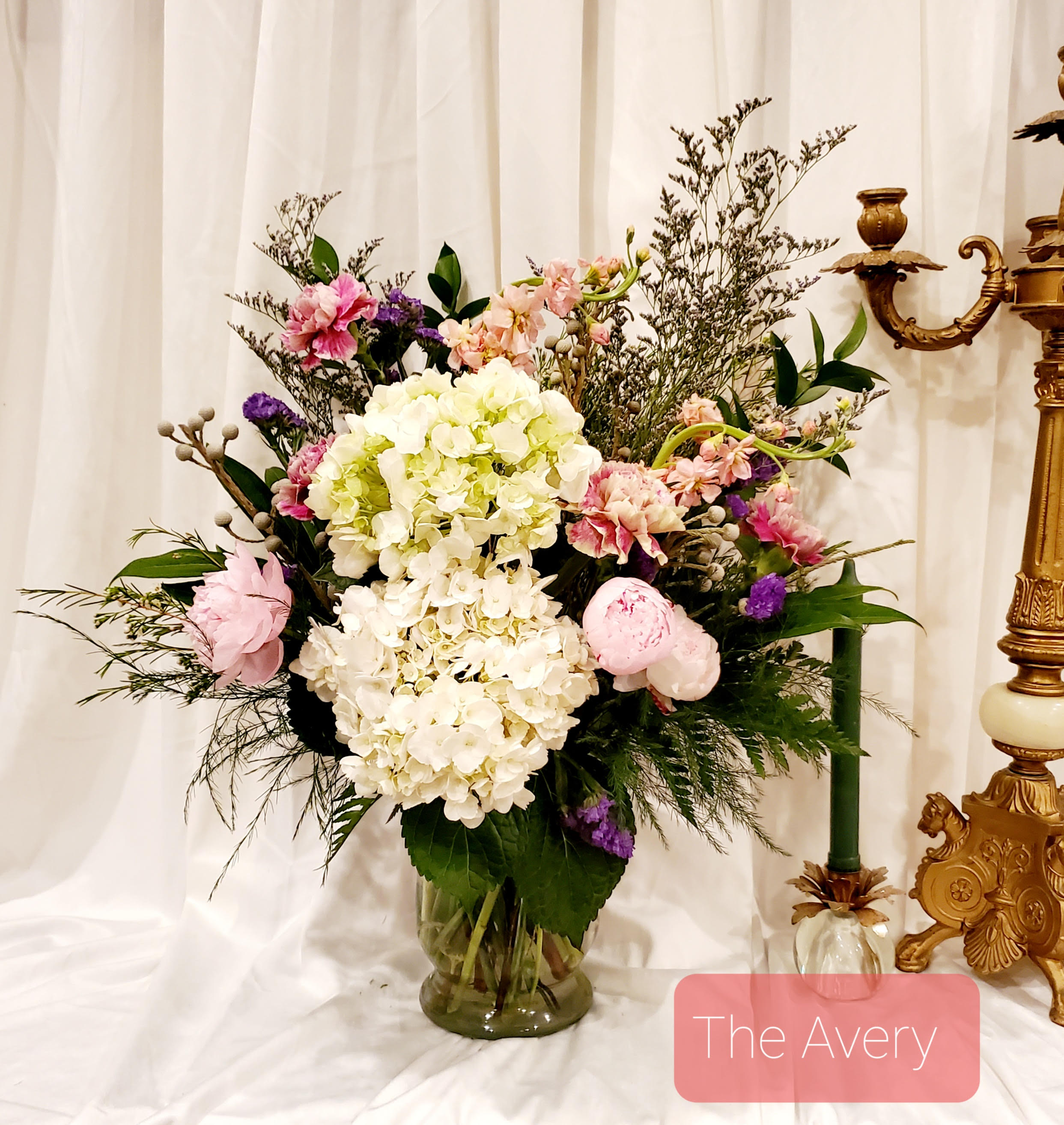 Mixed pink, white, and purple floral arrangement in a glass vase