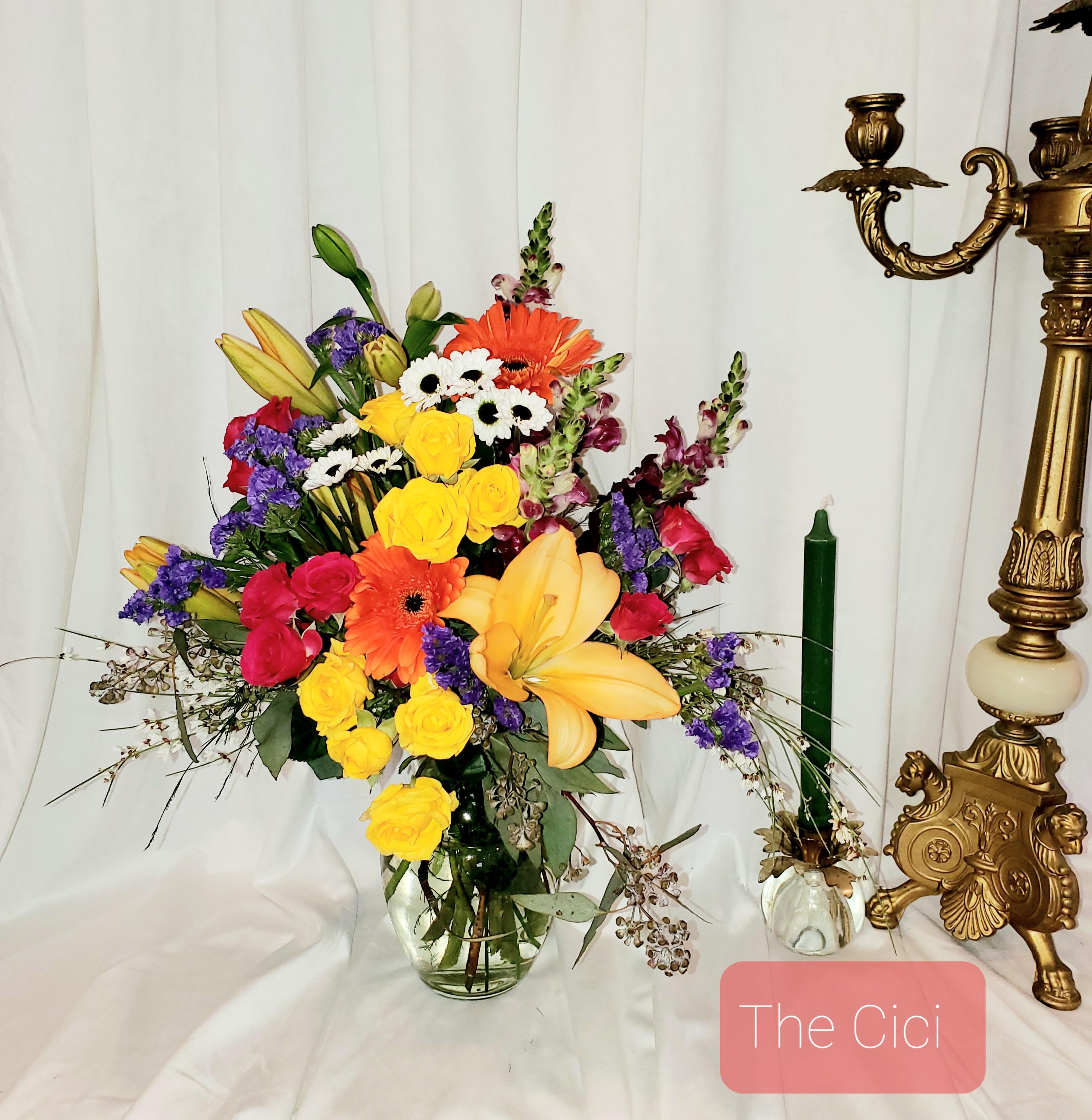 Colorful mixed bouquet in a clear glass vase with lilies and roses