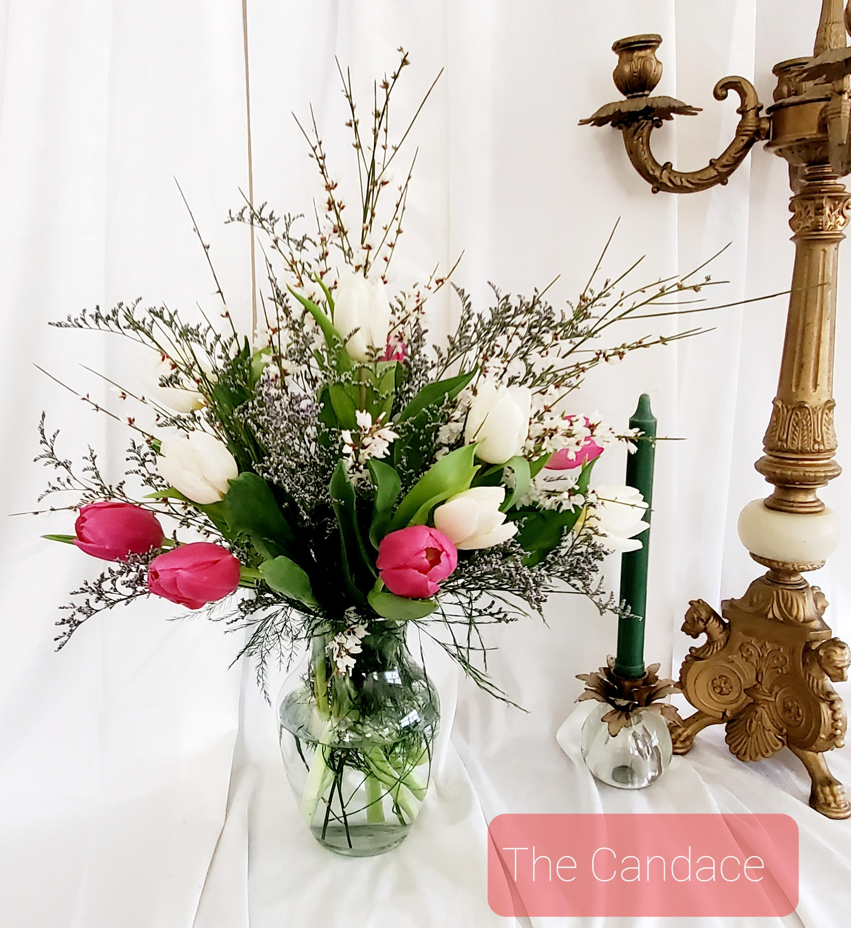Pink and white tulips in a glass vase with airy filler