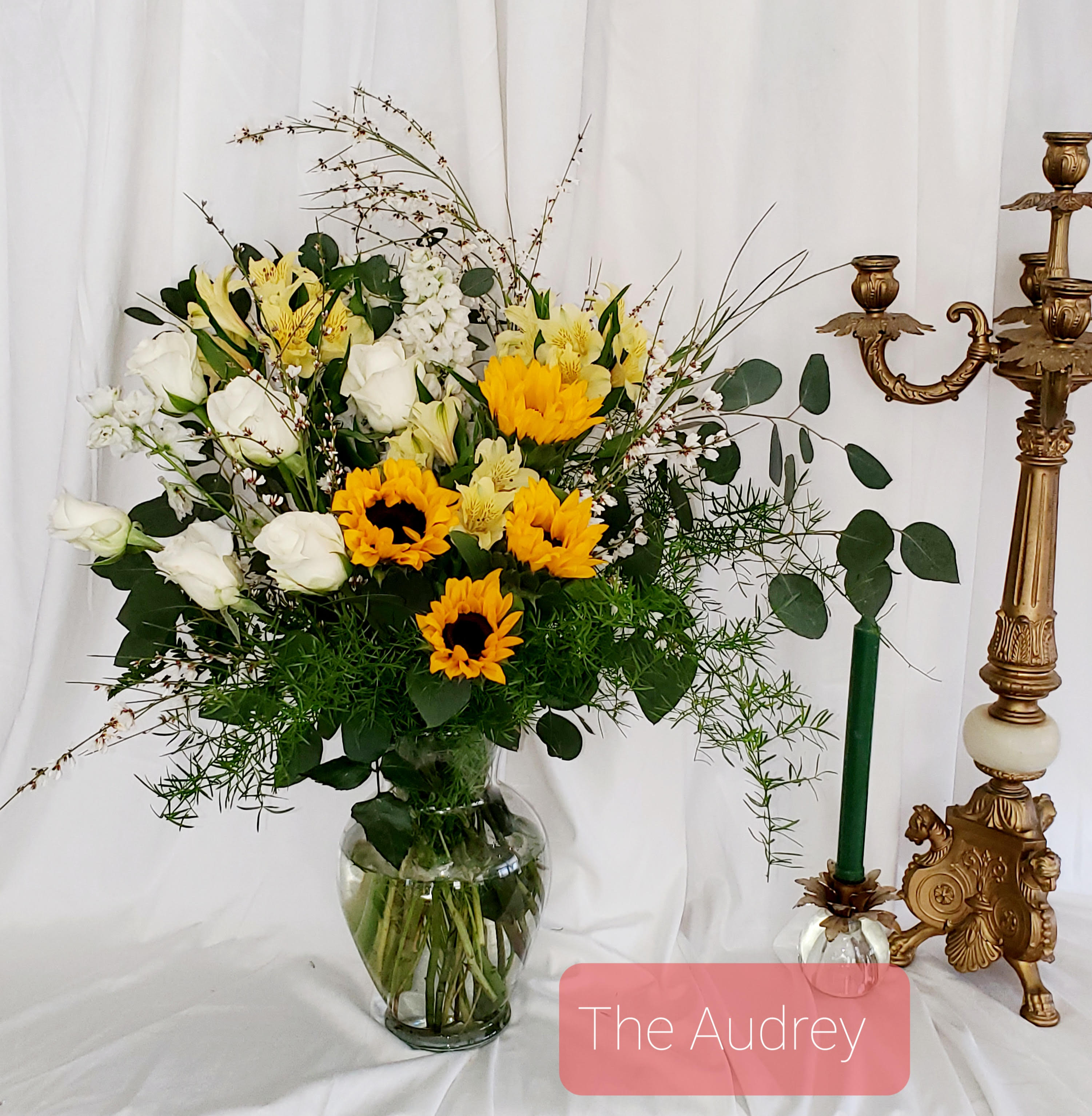 Bouquet of white roses and yellow sunflowers in a glass vase