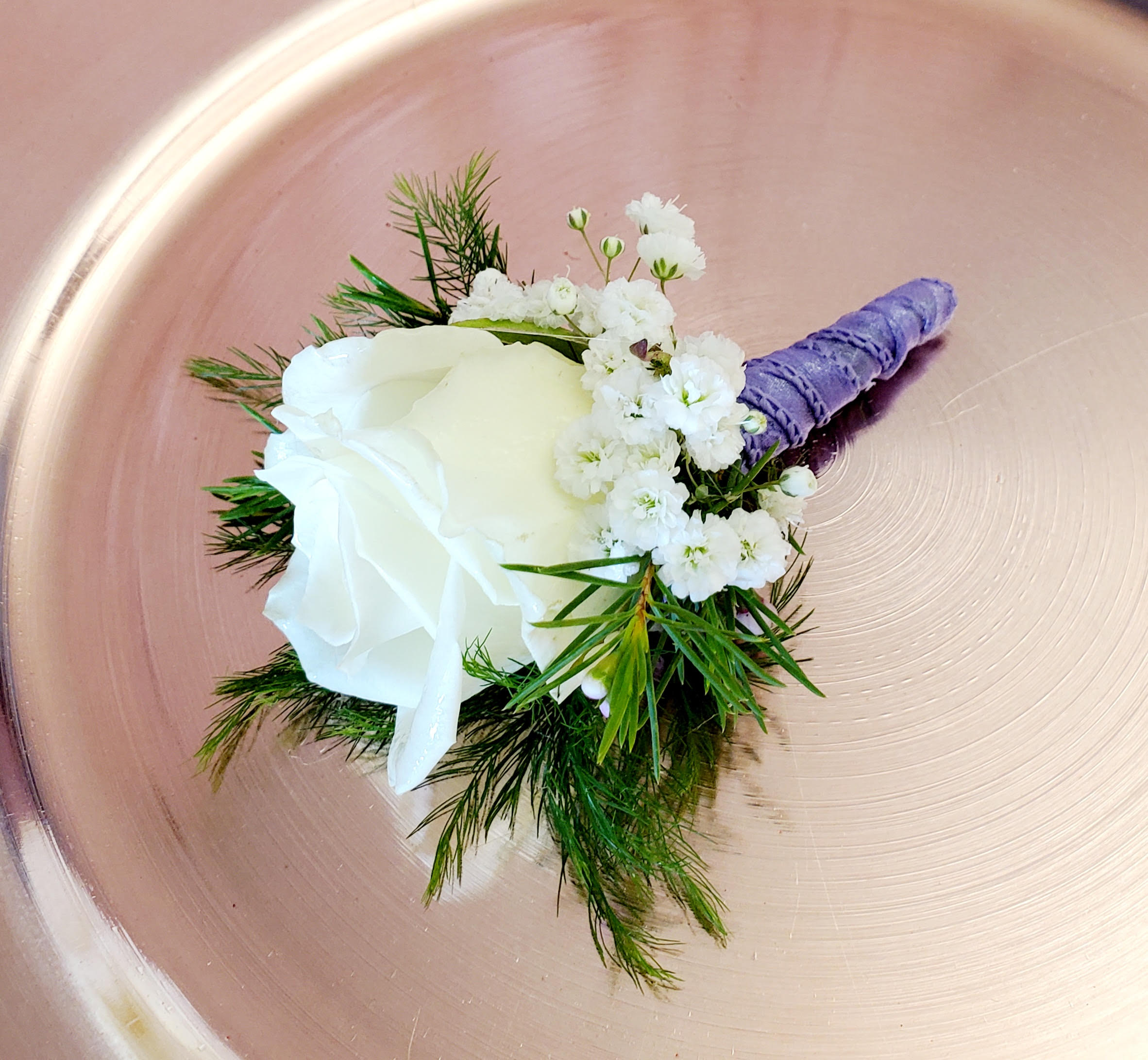 White rose boutonniere with baby's breath and purple wrapped stem
