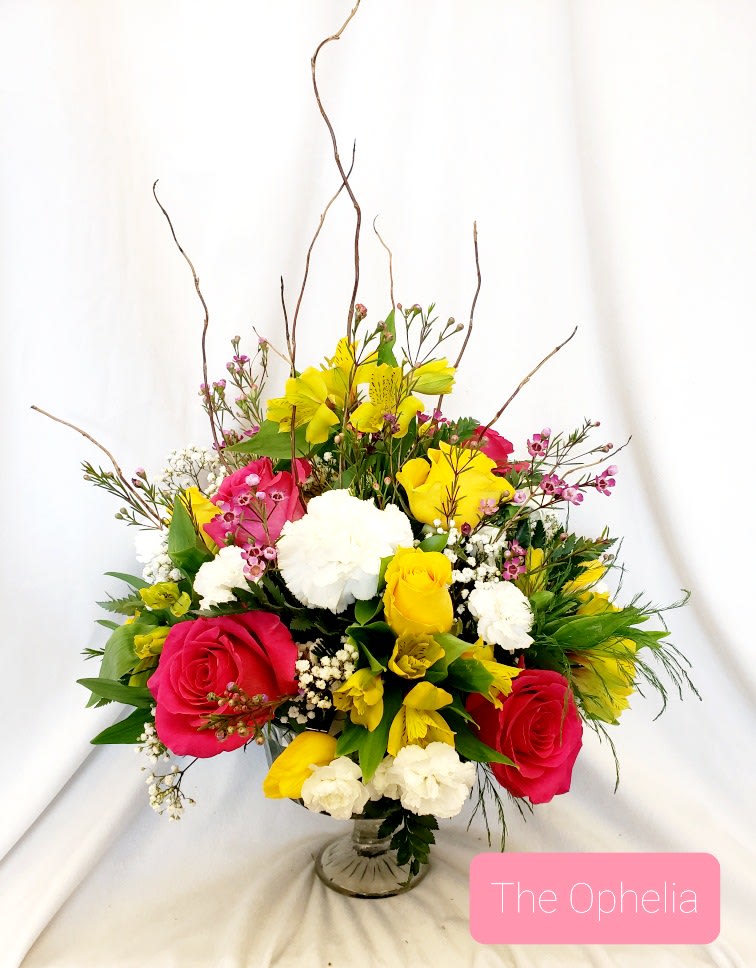 Bright mixed bouquet of pink, yellow, and white flowers in a glass vase