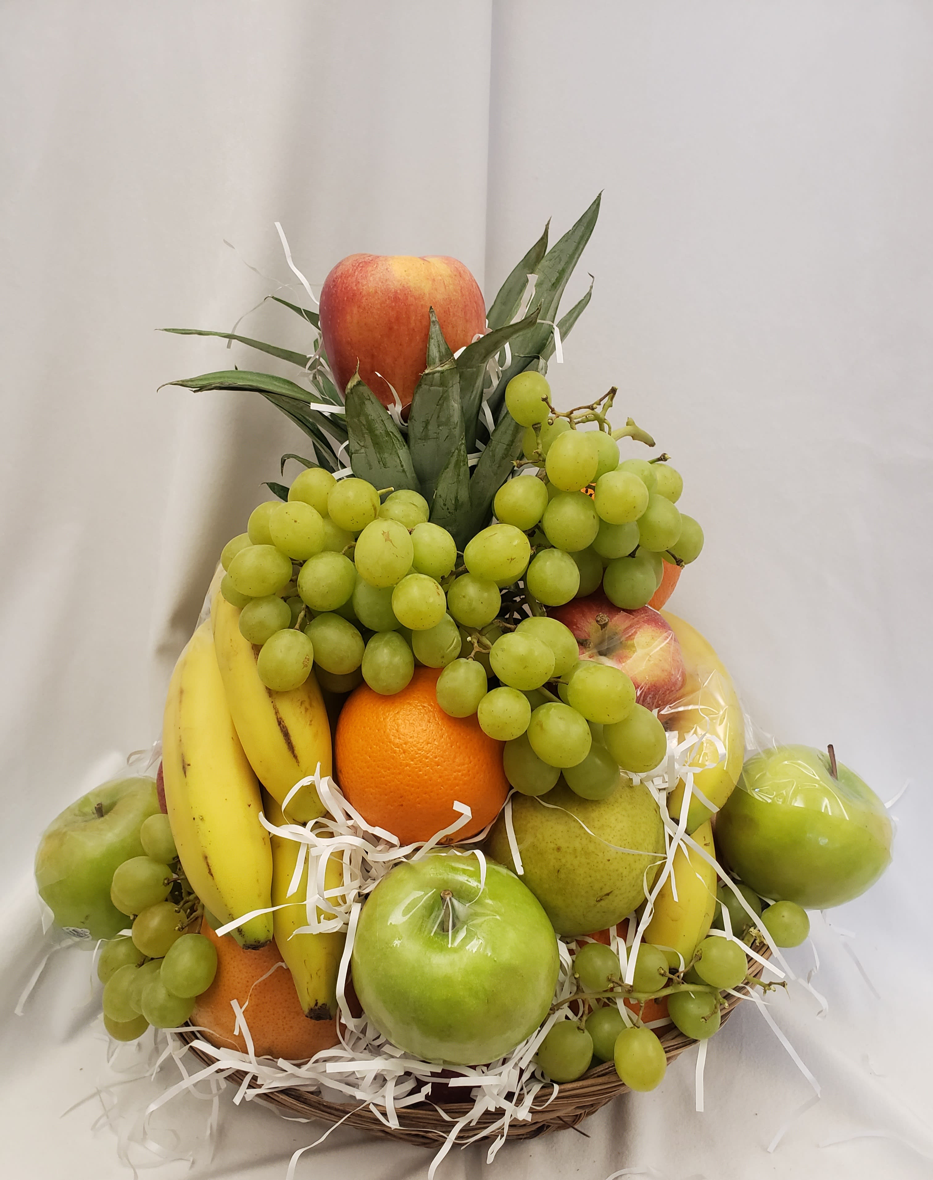 Fruit basket with grapes, bananas, apples, oranges, and pears