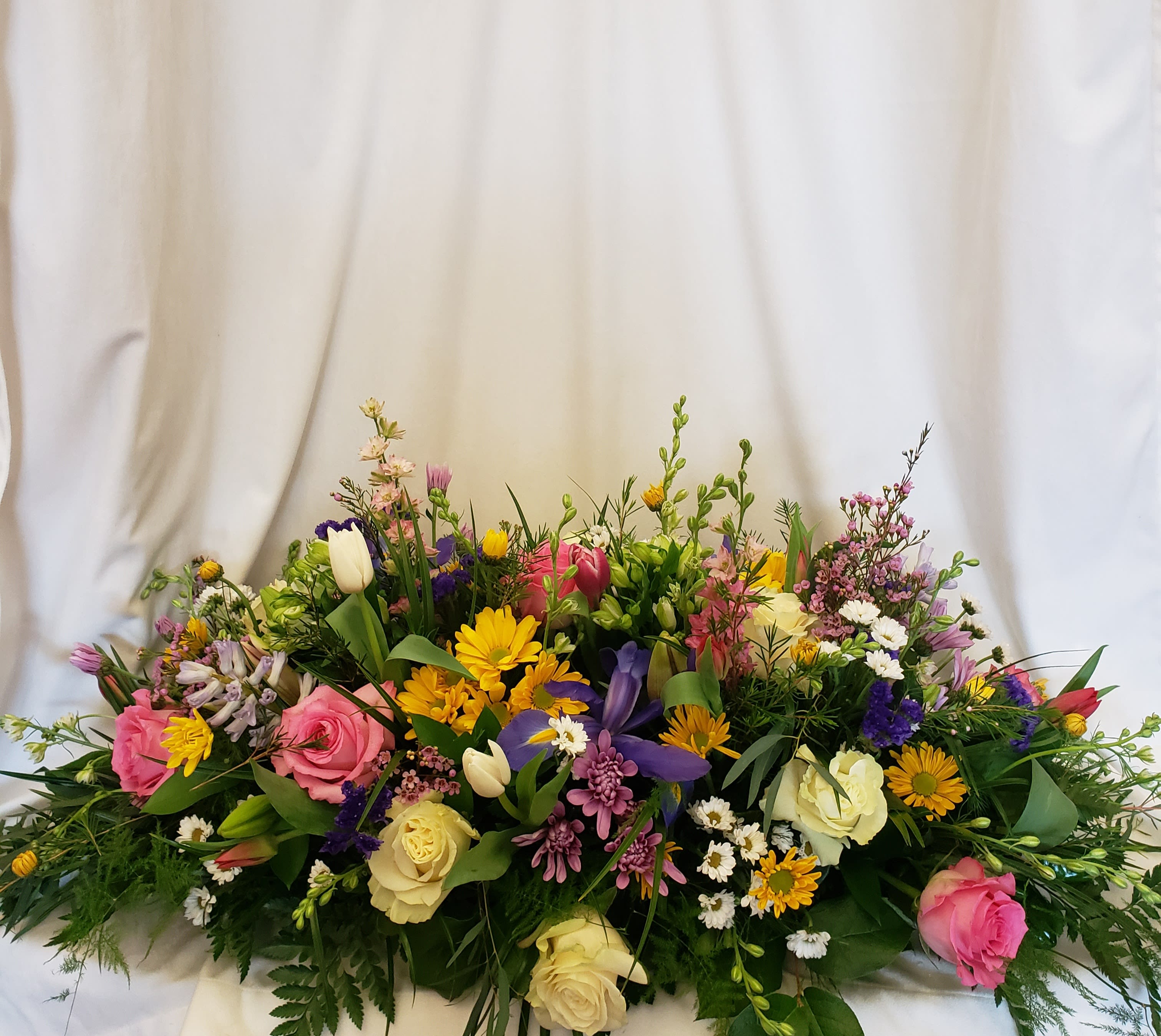 Large mixed bouquet with roses, tulips, and daisies in pink, yellow, purple, and white