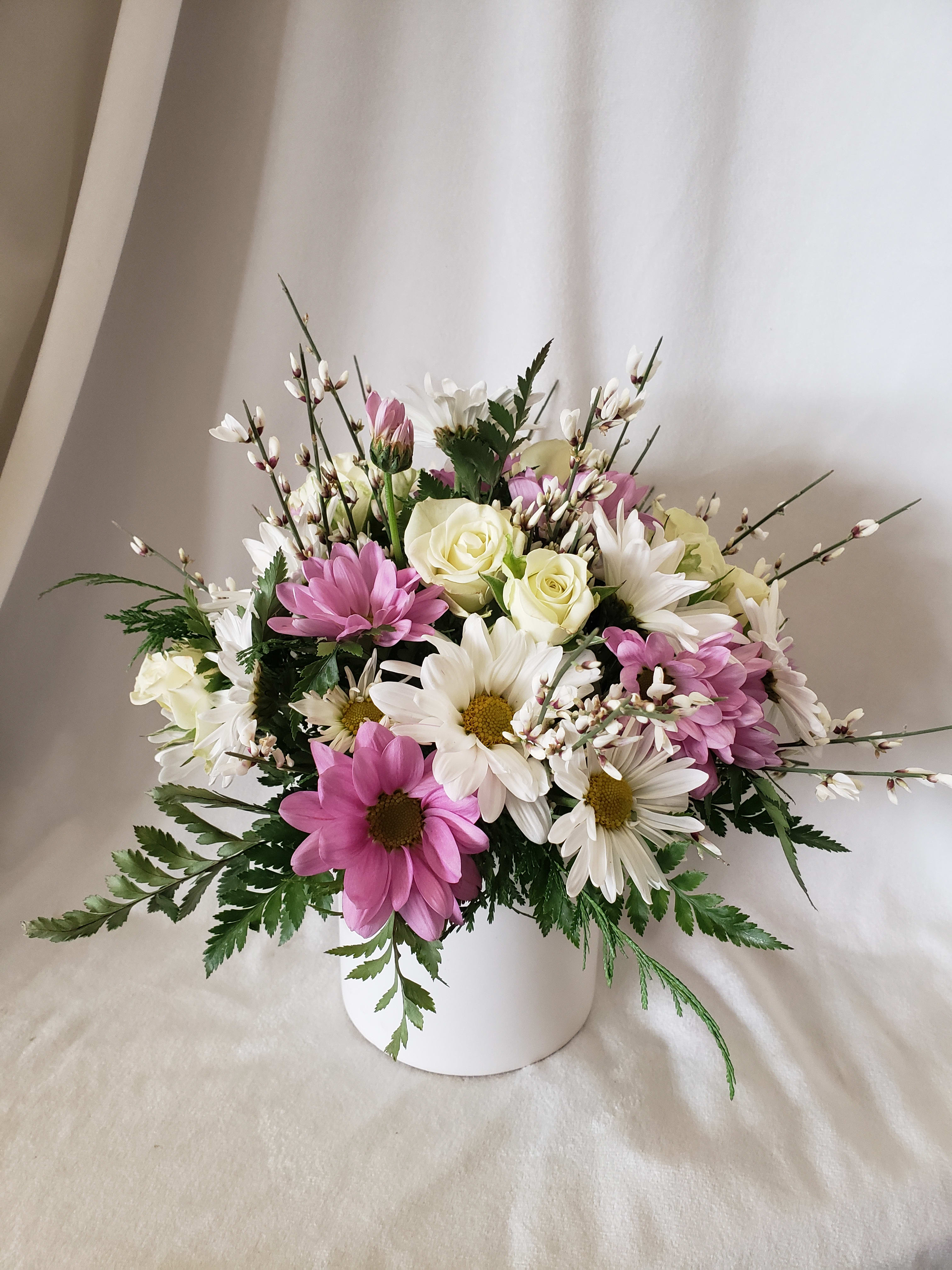Pink and white daisy bouquet in a white vase