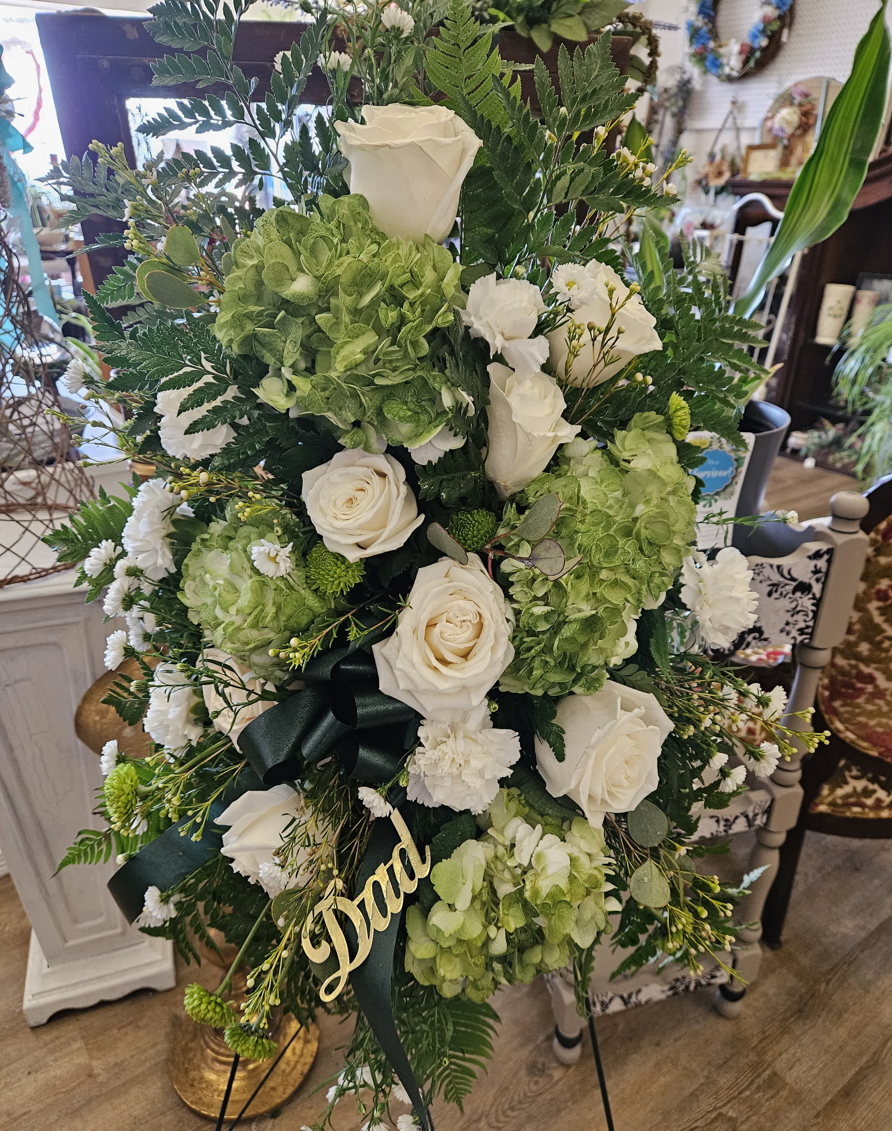Tall floral standing spray with white roses and green hydrangeas