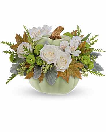 White roses and pale blooms arranged in a light green pumpkin-shaped container