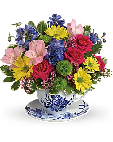 Colorful mixed bouquet in a blue-and-white teacup and saucer