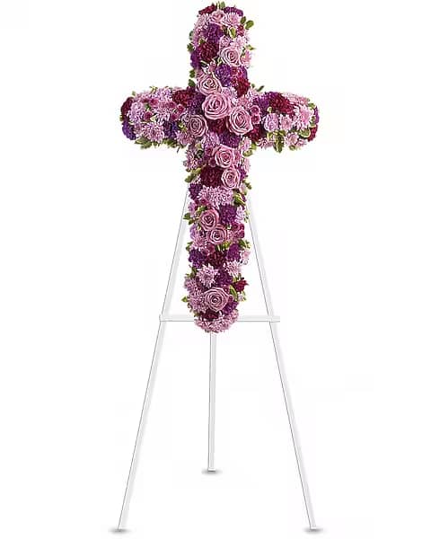 Purple and pink floral cross on a white stand