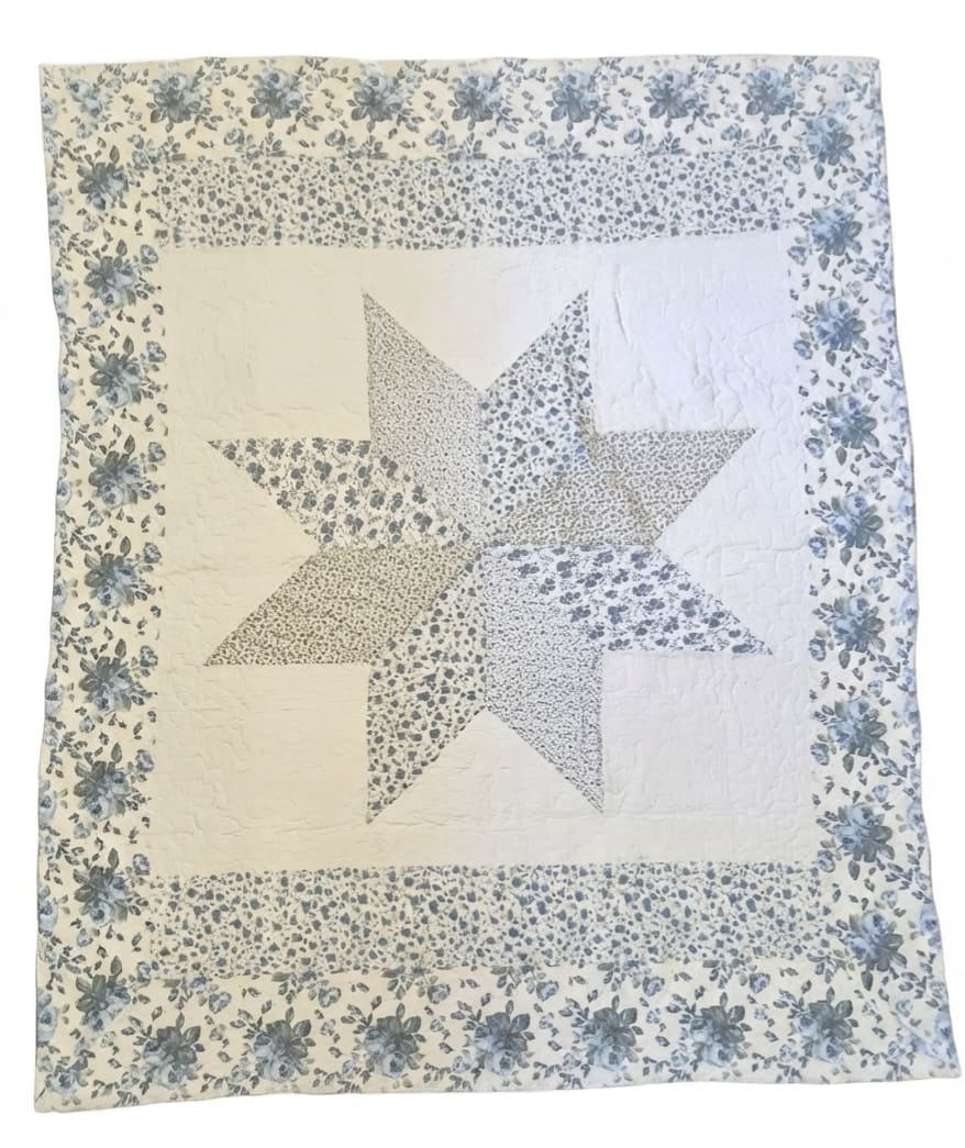 Patchwork quilt with a large star pattern and floral border