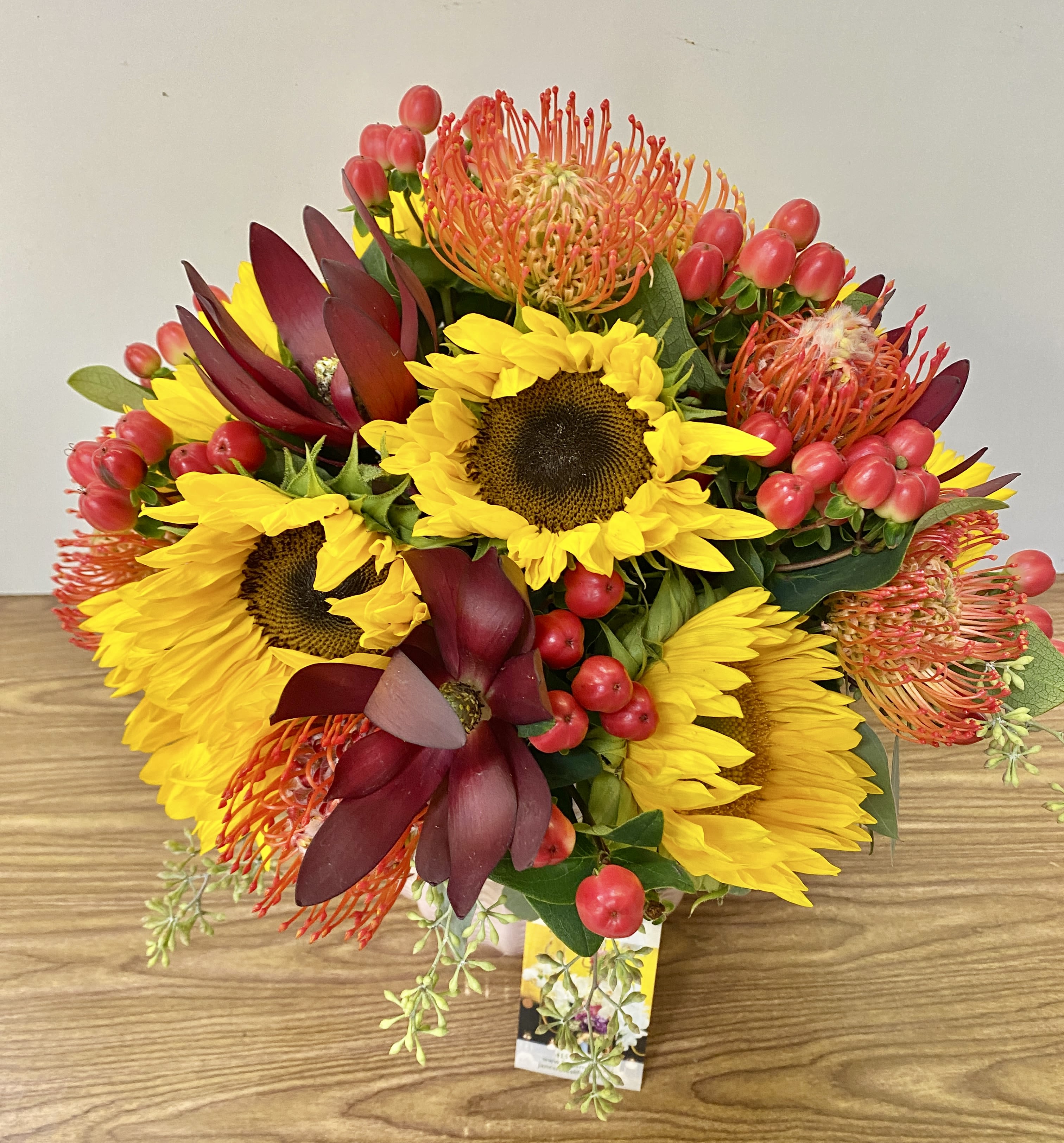 Bouquet of yellow sunflowers with burgundy and orange tropical blooms