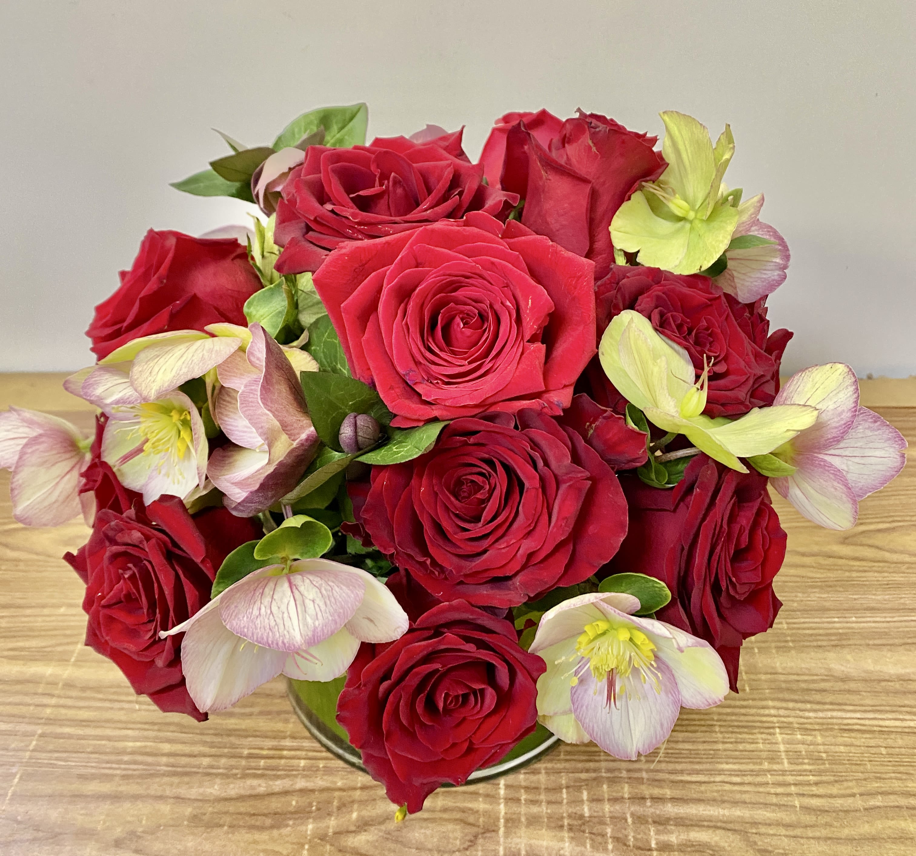 Bouquet of red roses with pale pink and green hellebore blooms