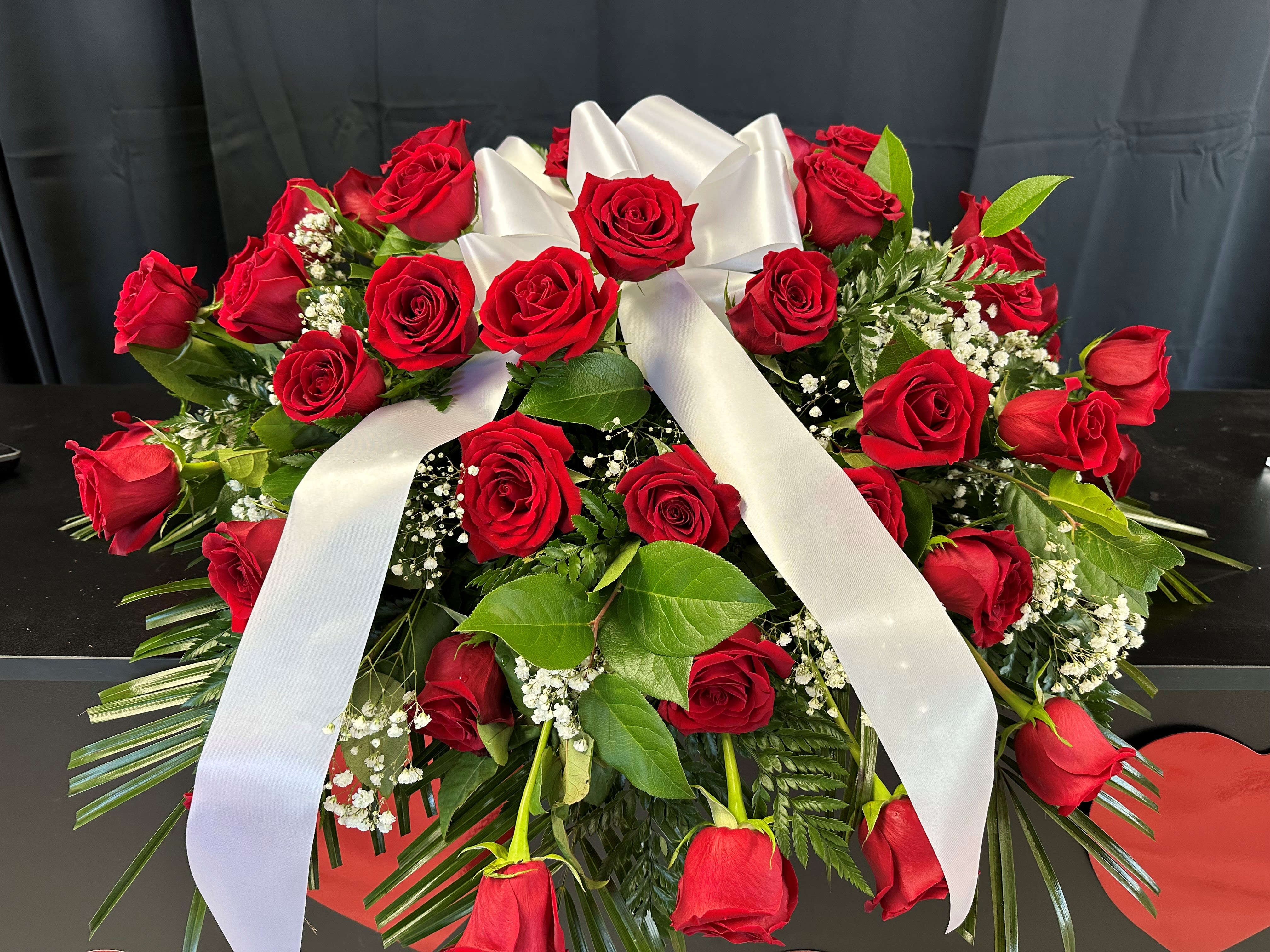 Red rose arrangement with a white ribbon bow