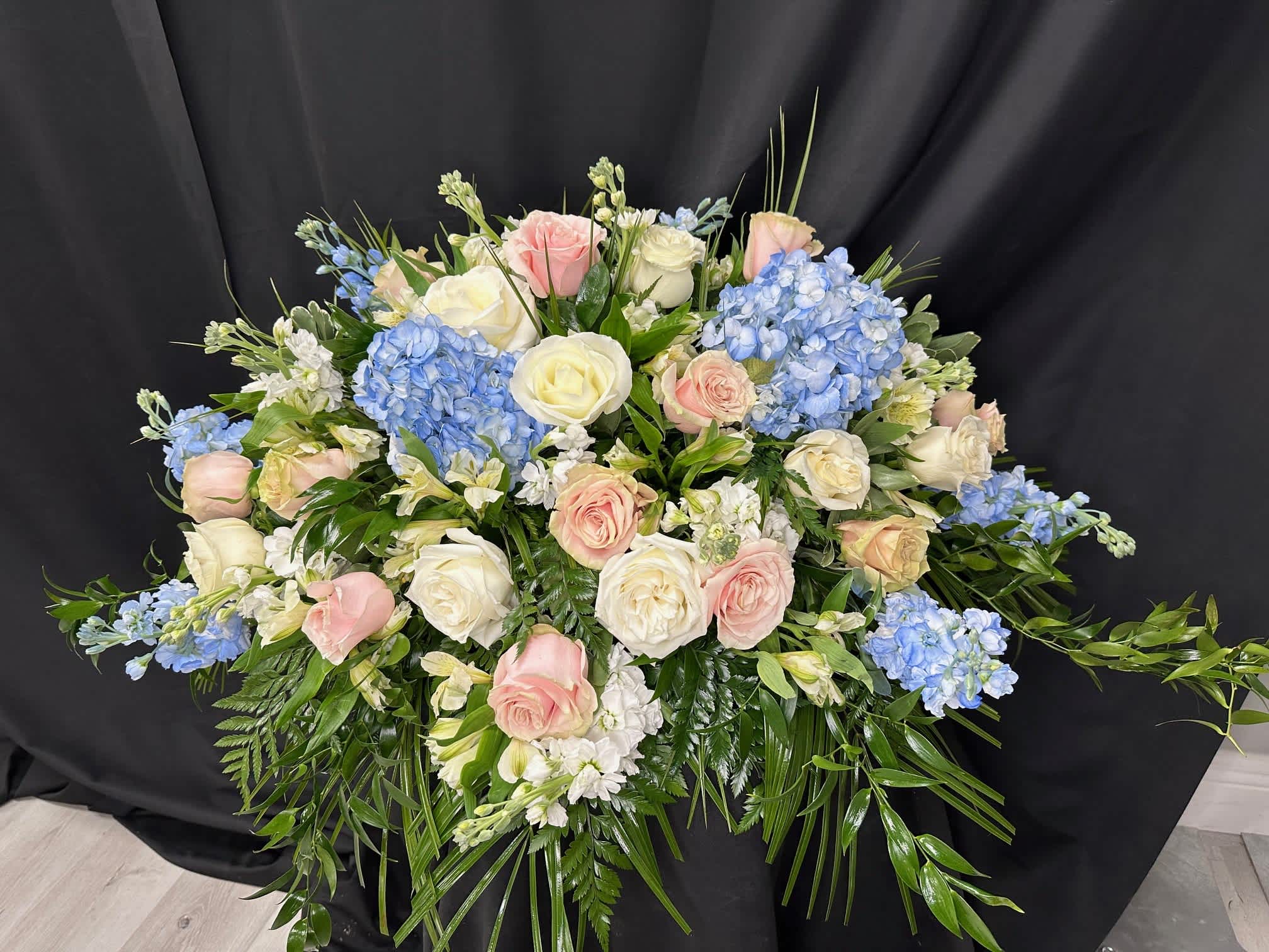 Large bouquet of pink and white roses with blue hydrangeas
