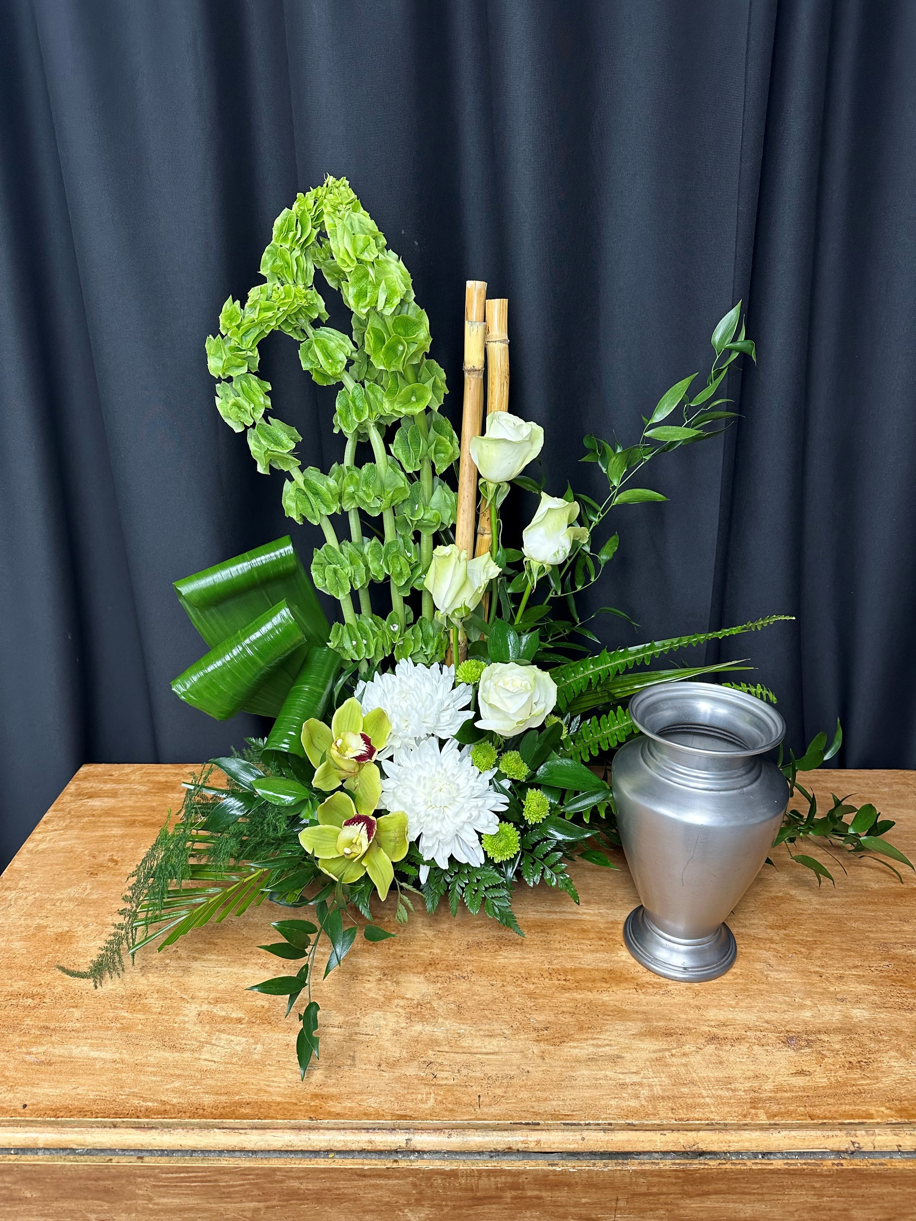Irish Eyes - The Irish Eyes urn arrangement is a lush, all-green tribute that exudes natural beauty and heartfelt remembrance. Filled with rich greenery, this elegant piece offers a serene and timeless homage to your loved one. Irish Eyes reflects the quiet strength and peaceful spirit of nature, creating a fitting symbol of love, remembrance, and eternal rest.