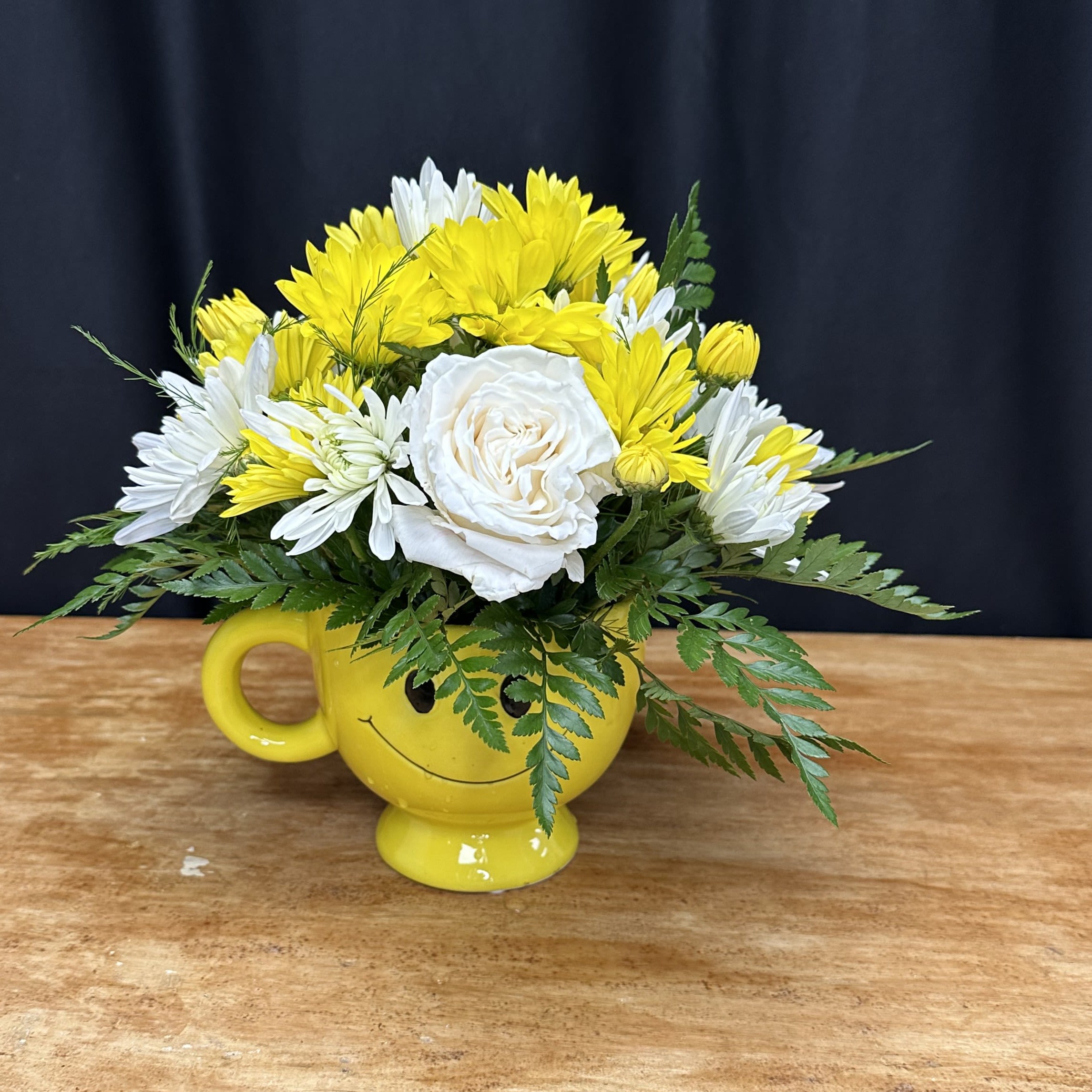 Be Happy Bouquet  - Bright yellow and crisp white flowers adorn a cheerful yellow smiley face mug, radiating warmth and happiness. Against the sunny backdrop of the mug's cheerful design, the blooms bring a sense of joy and positivity to any space. This delightful arrangement is sure to bring smiles and lift spirits with its playful charm.