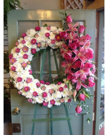 Large floral wreath with pink lilies and white daisies on a door