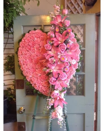 Large pink heart-shaped floral arrangement on an easel