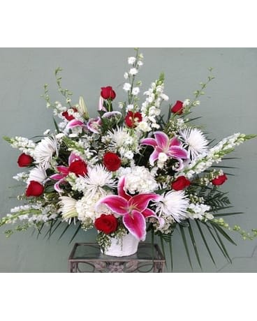 Large bouquet of red and pink flowers in a white vase