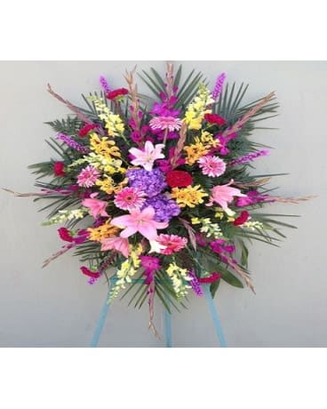 Large standing spray of mixed pink, purple, yellow, and white flowers