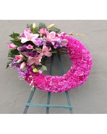 Pink floral wreath with lilies and roses on a stand