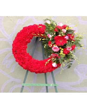Red floral wreath on an easel with pink and white accents