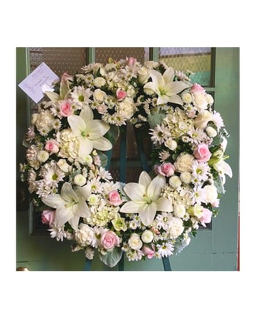 Large white floral wreath with pink roses and lilies