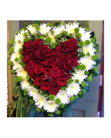 Heart-shaped red rose wreath with white flowers and green accents