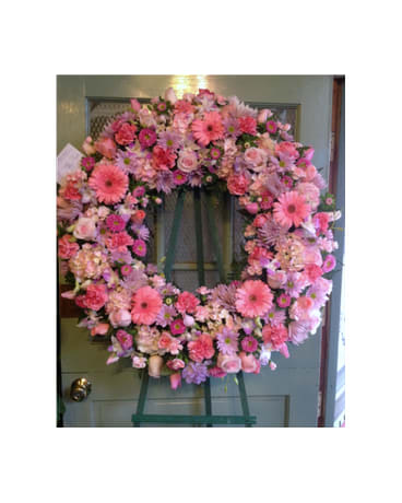 Pink floral wreath on a green easel stand