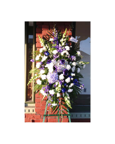 Tall standing floral spray with white and purple flowers on an easel