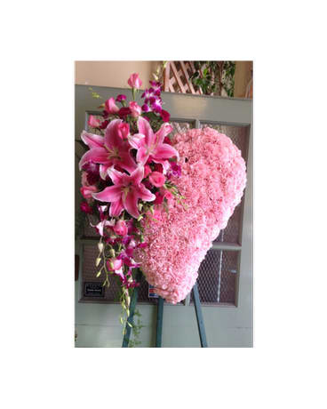 Heart-shaped pink floral standing spray with lilies and orchids