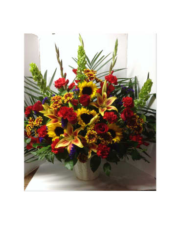 Large mixed bouquet with sunflowers, lilies, and red roses in a vase