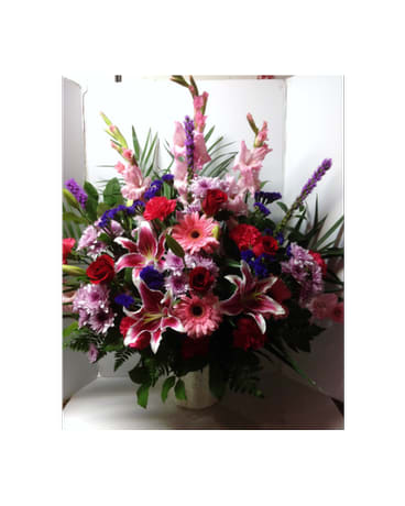Large mixed bouquet of pink, red, and purple flowers in a vase