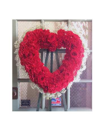Heart-shaped red floral wreath on an easel