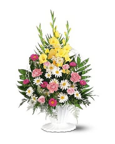 Standing floral arrangement with yellow, pink, and white flowers in a white pedestal vase