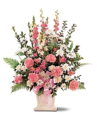 Pink and white floral arrangement in a square vase with a pink ribbon