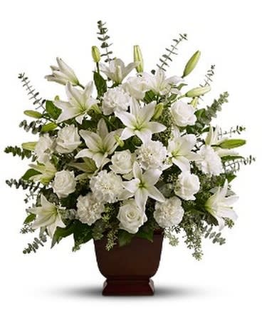 White lilies and roses arranged in a brown urn vase