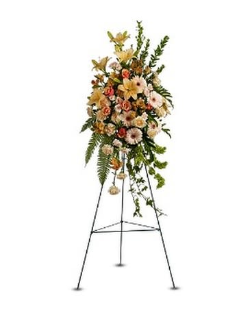 Standing floral spray on an easel with pale mixed flowers and greenery