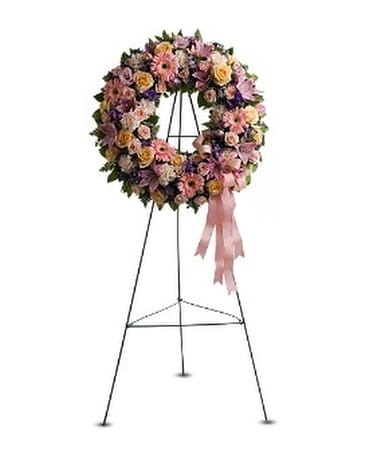 Floral wreath on a metal easel with a pink ribbon
